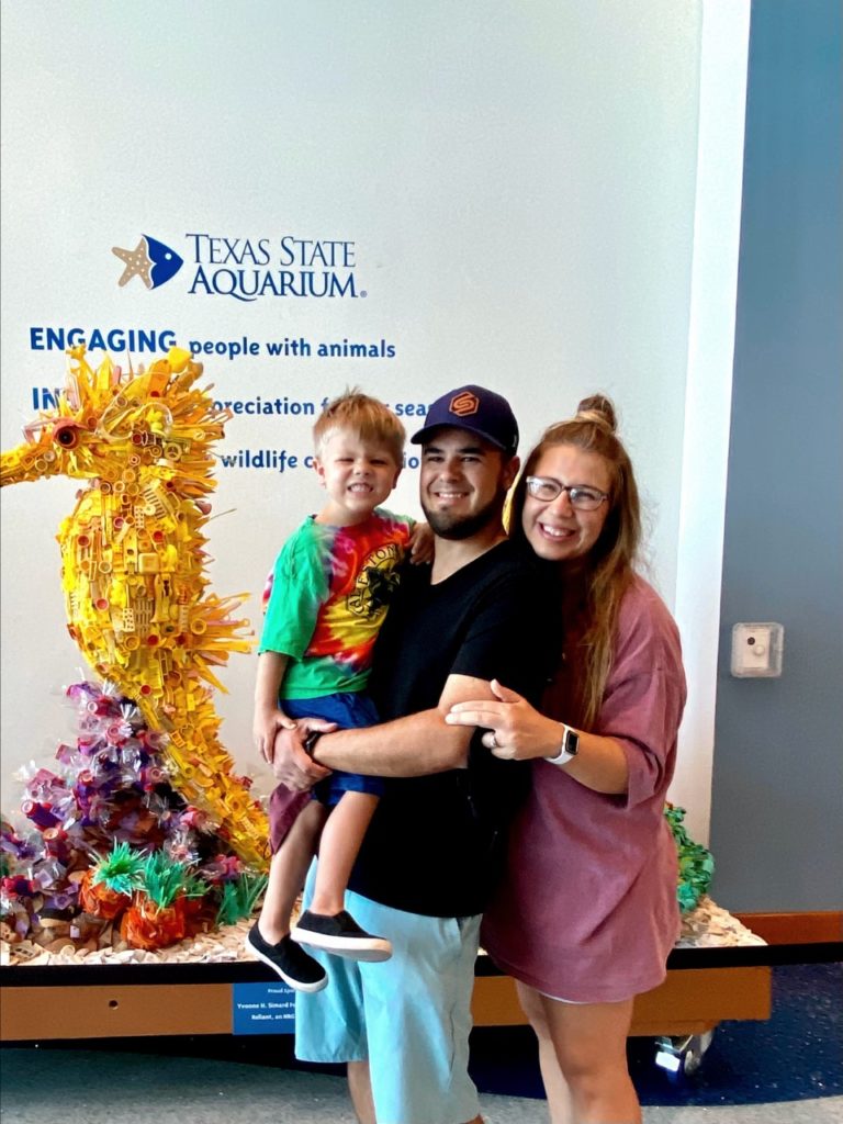 Family posing together in front of a colorful sea-themed sculpture at Howard Payne University. | HPU